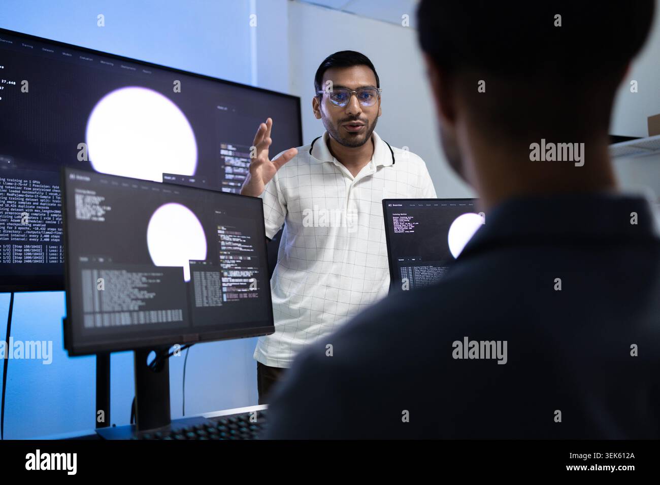 Indian Coding Instructor Teaching AI Programming Lesson To Student In Tech Office Stock Photo