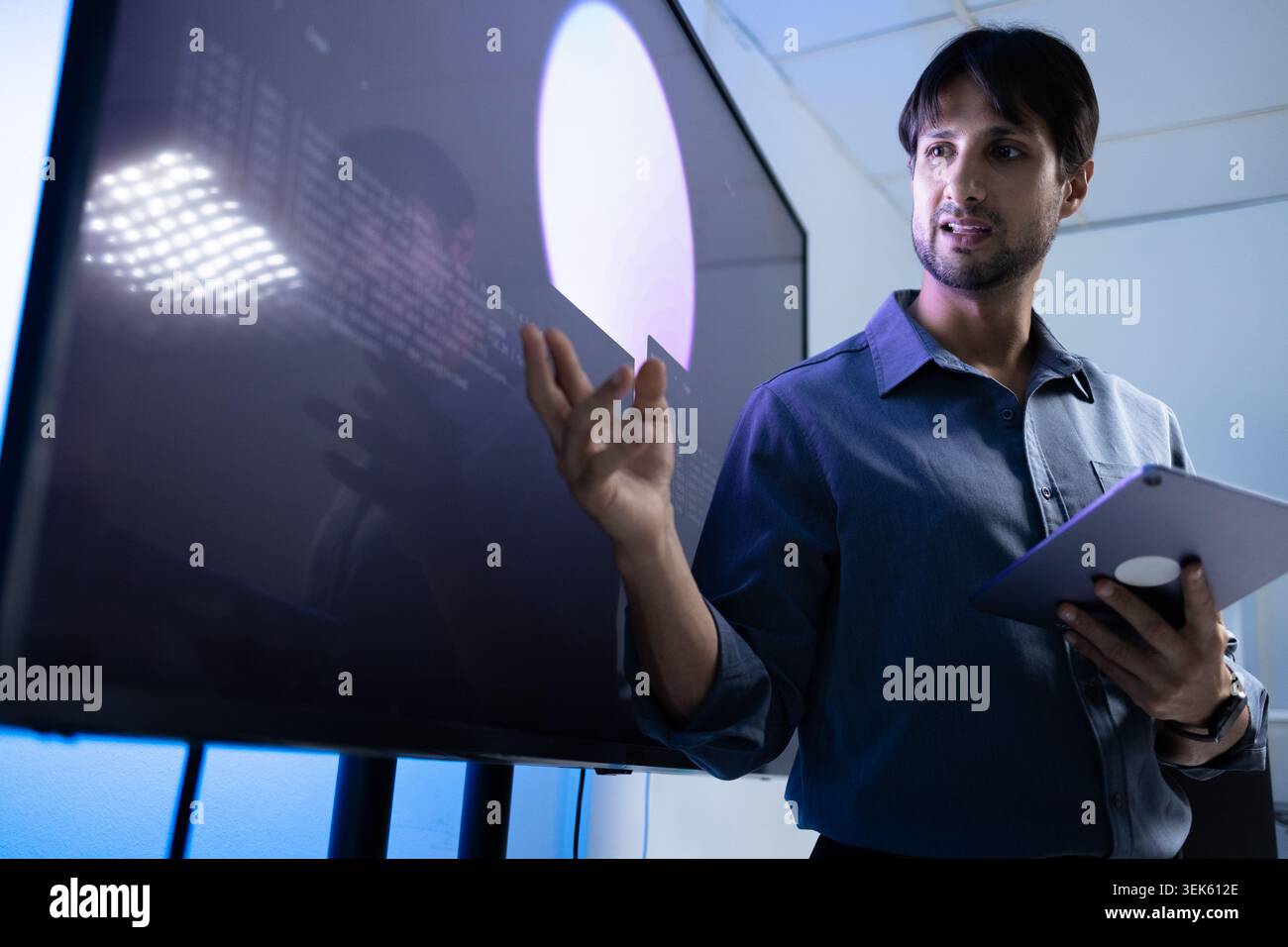 Latin Programming Instructor Teaching AI Training With Tablet In Tech Office Stock Photo