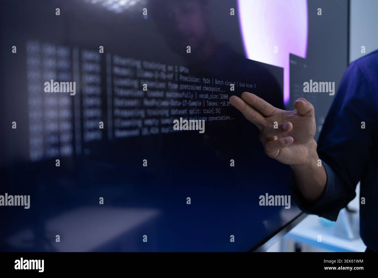Hand Pointing At AI Training Code On Digital Screen Stock Photo