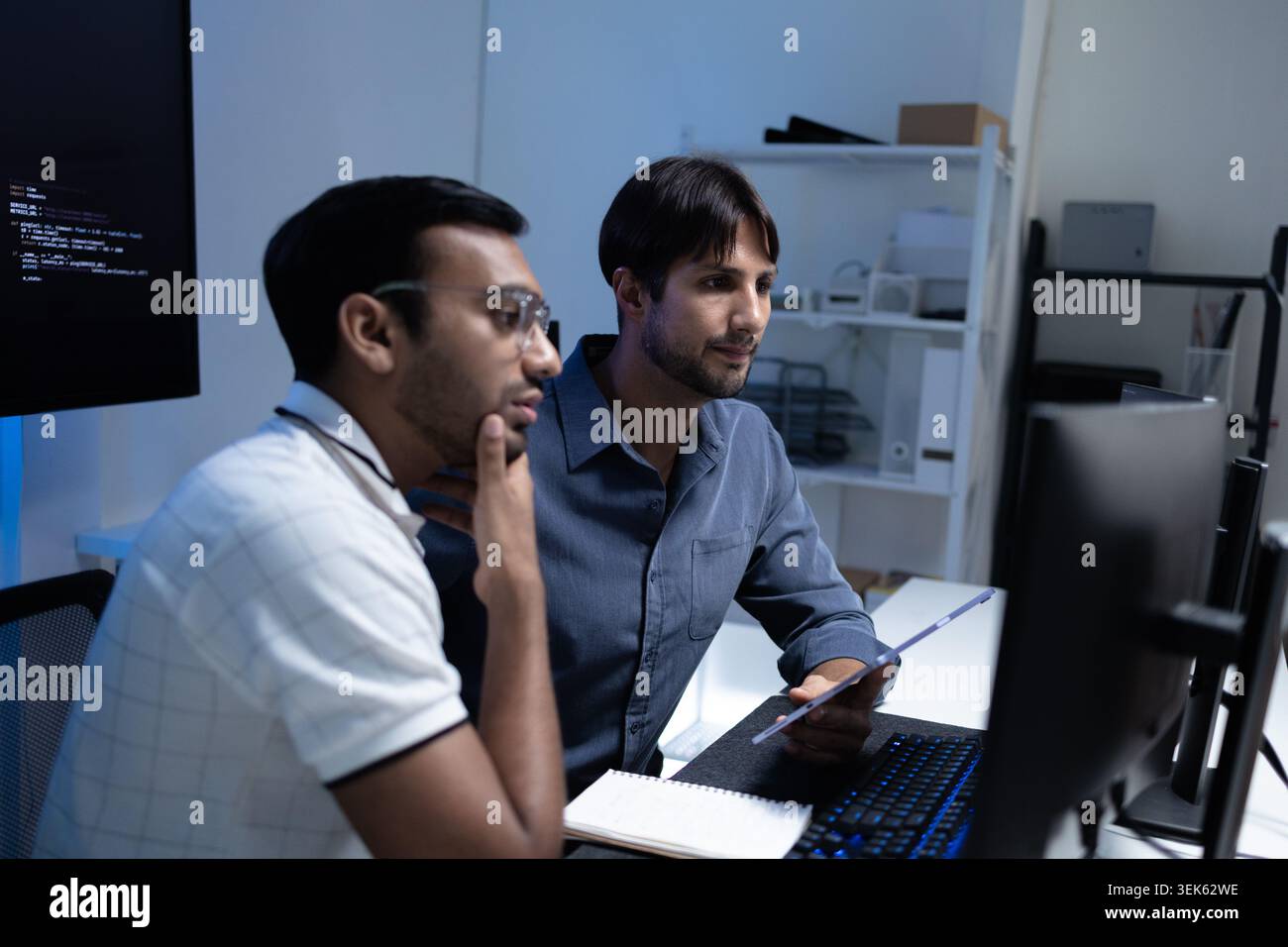 Focused Software Developers Working Together At Computer In Tech Office Stock Photo