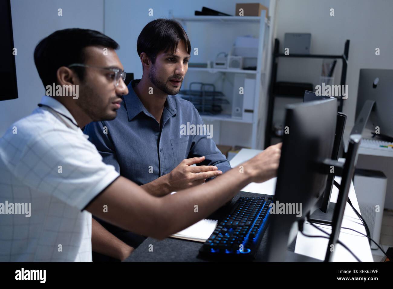 Focused Software Developers Working Together At Computer In Tech Office Stock Photo