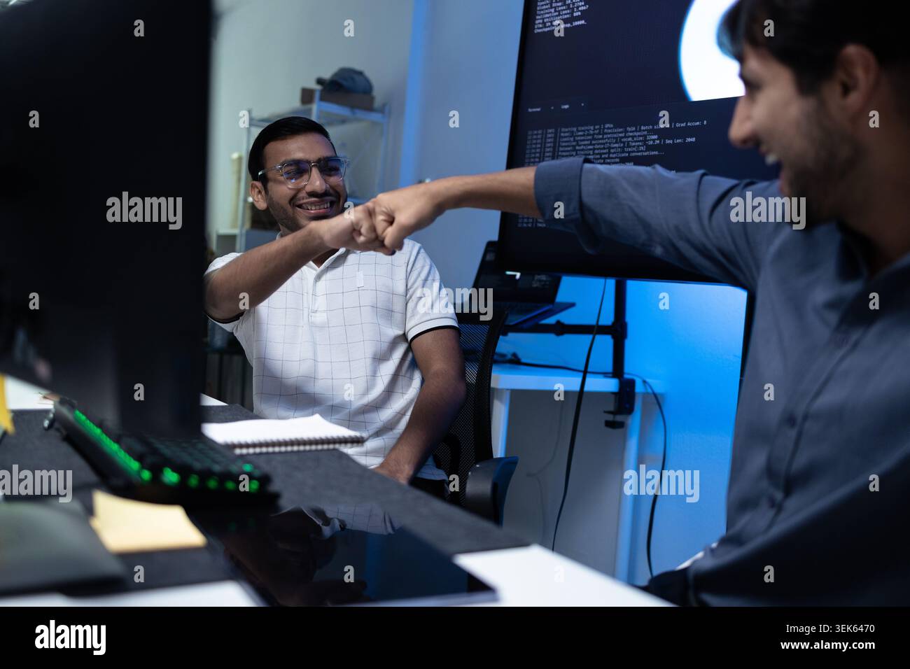 Software Developers Celebrating Success With Fist Bump In Tech Office Stock Photo