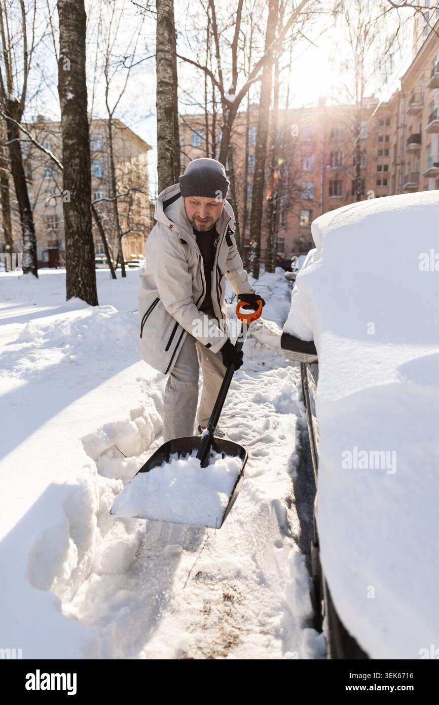 Man shoveling deep snow from his car Stock Photo