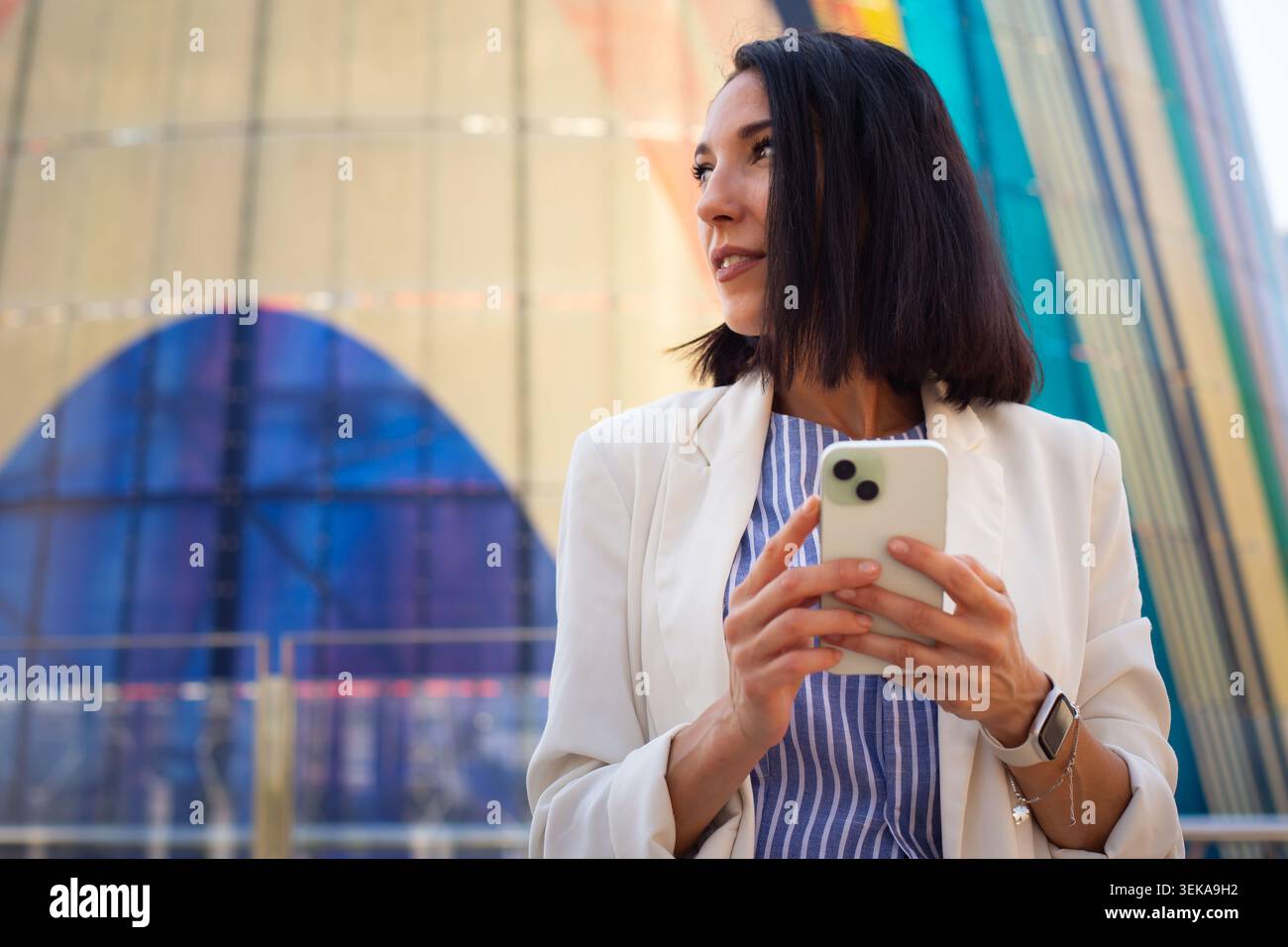 Young professional woman using smartphone in modern urban business district Stock Photo