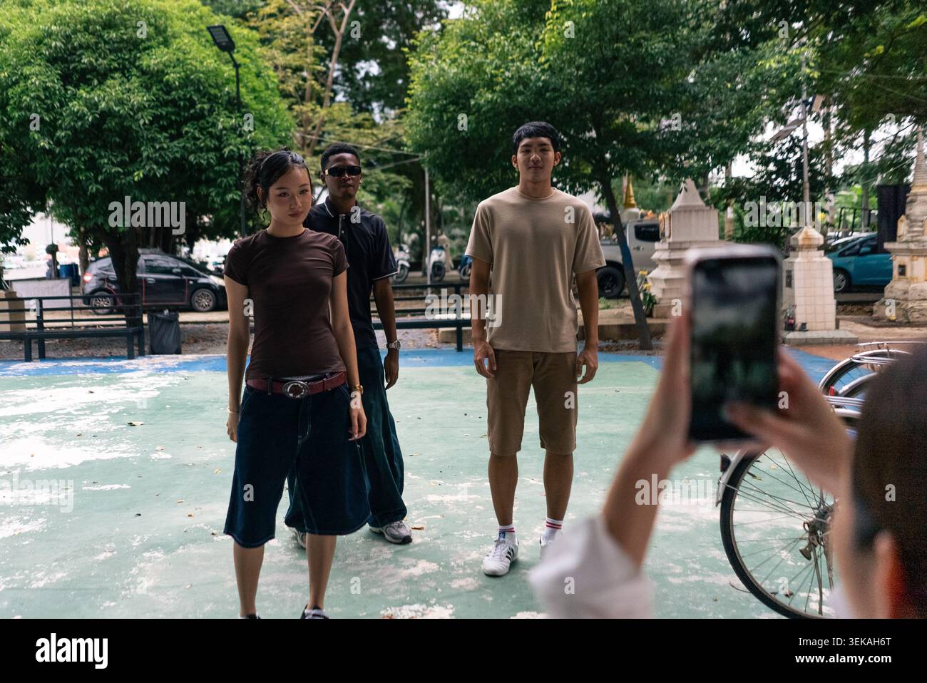 Young people posing for smartphone picture, creating content outdoors Stock Photo