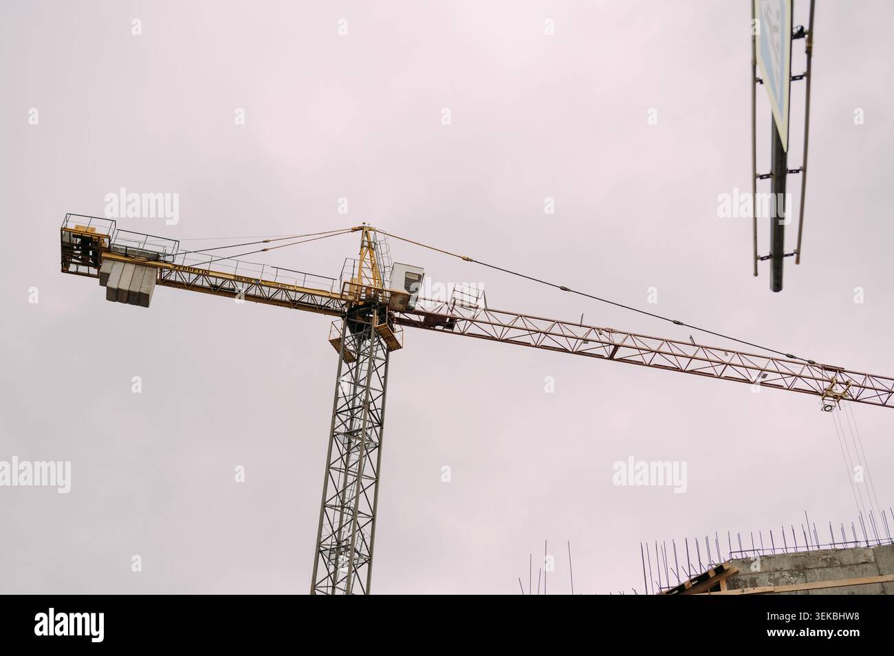 Tower crane at construction site against overcast sky Stock Photo