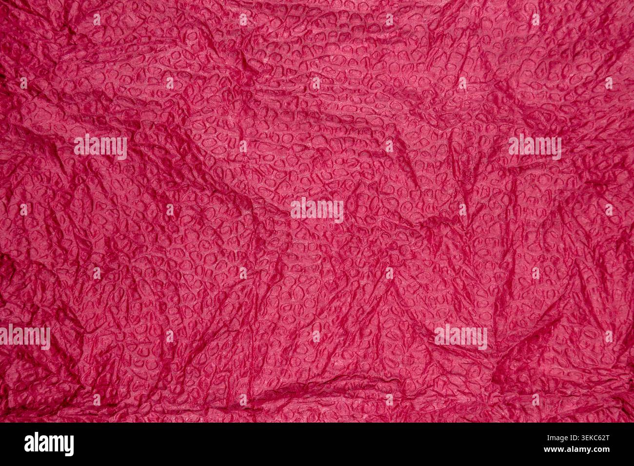 Red bubble wrap texture surface with glossy circular raised pattern Stock Photo