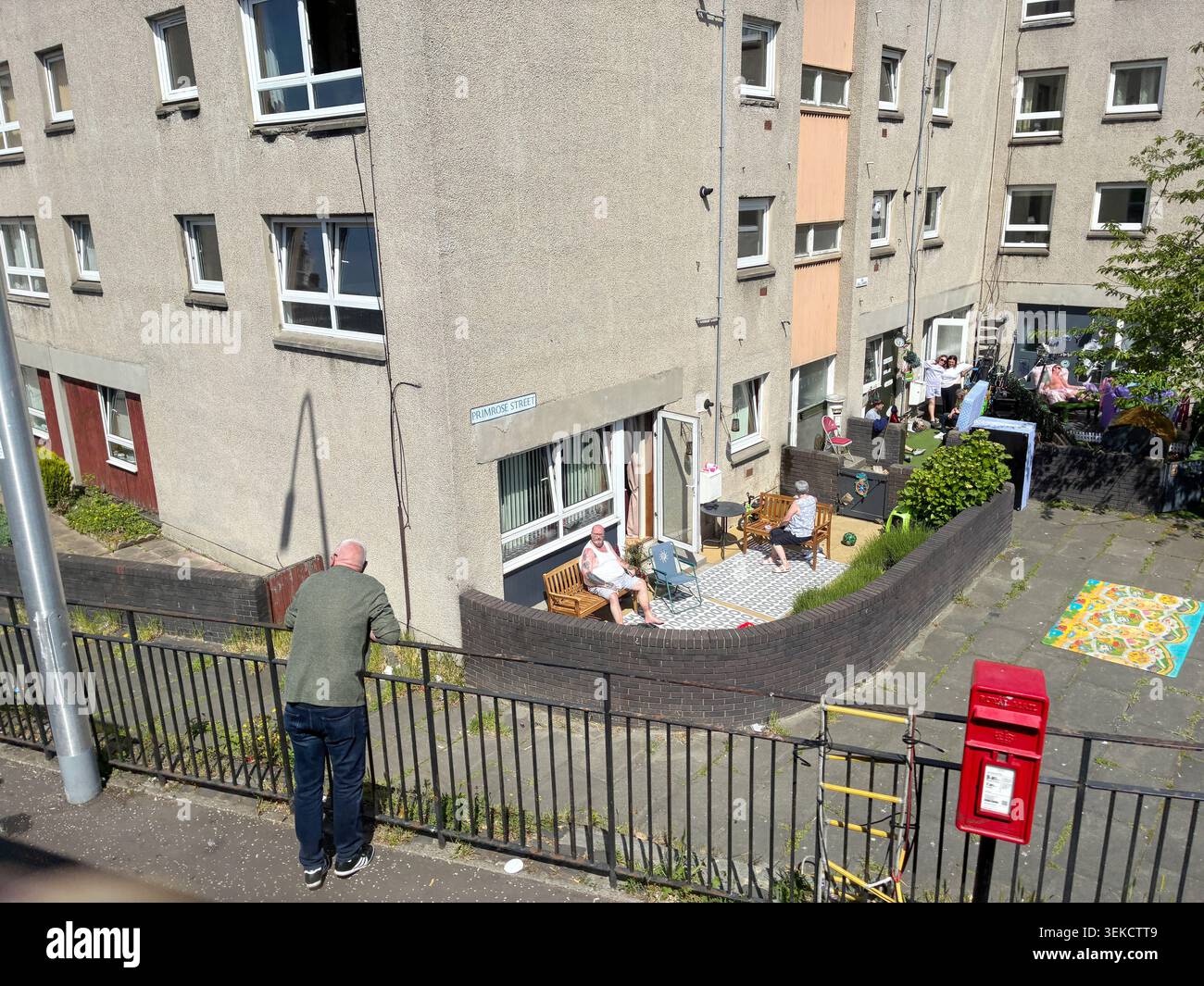 Leith Edinburgh Scotland UK - neighbours chat outside social housing flats on a sunny day in Leith - photo May 2026 - Smartphone Captured Stock Image