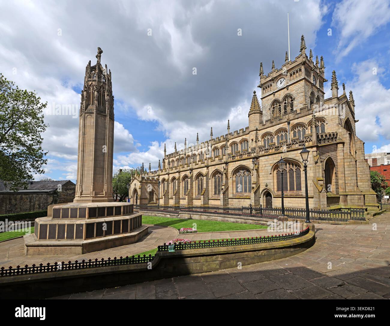 All Saints parish Church and Wigan War Memorial under bright clouds in the historic centre of Wigan, Greater Manchester. Stock Photo