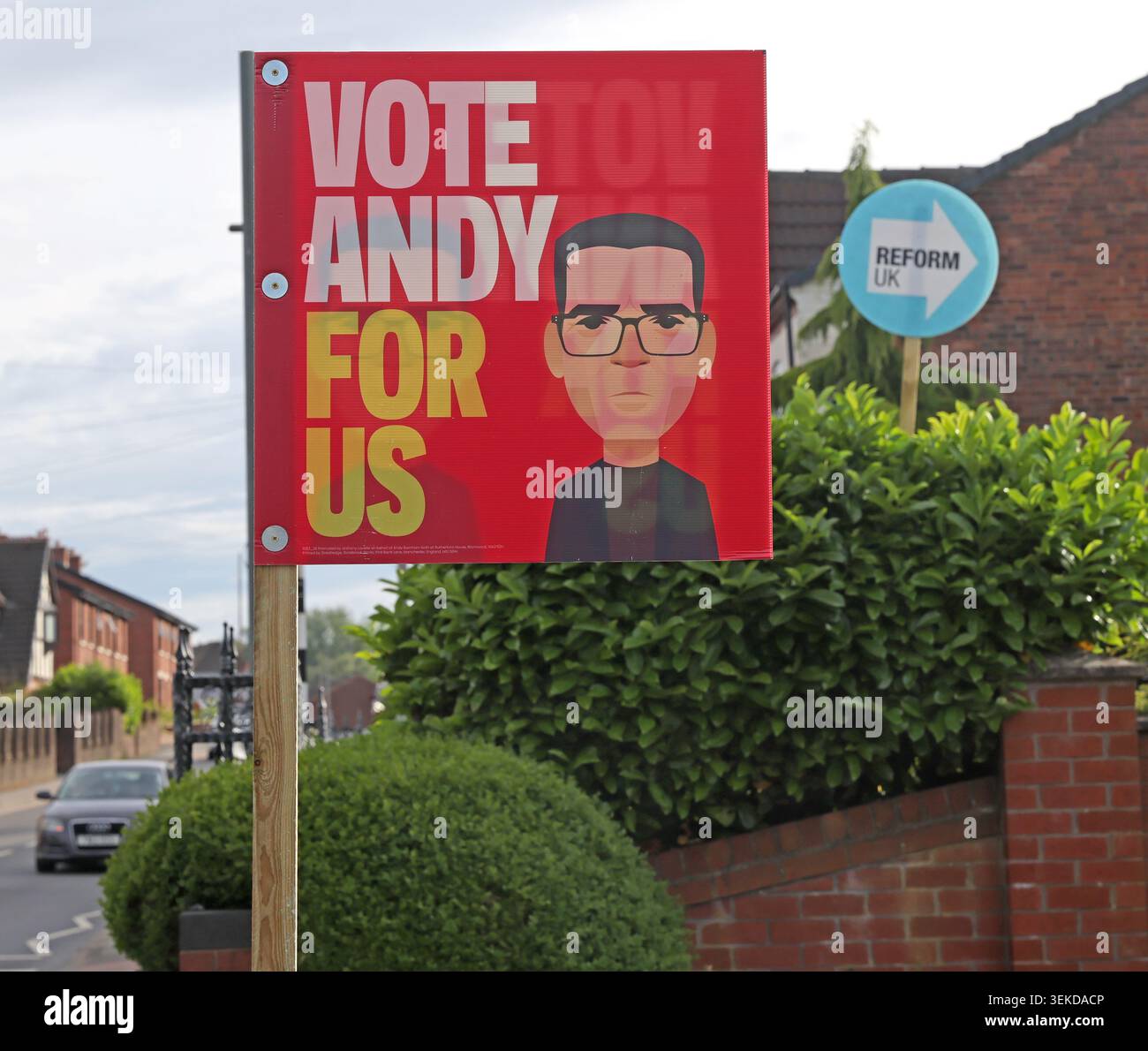 Labour Vote Andy For Us poster with Reform UK sign in an Ashton-in-Makerfield front garden during the Makerfield by-election. Stock Photo