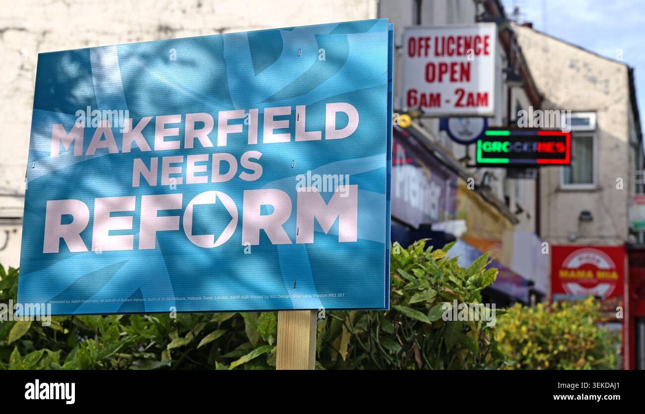 Blue Makerfield Needs Reform sign beside convenience store 6am-2am and off-licence signage in Ashton-in-Makerfield, Wigan, Greater Manchester Stock Photo