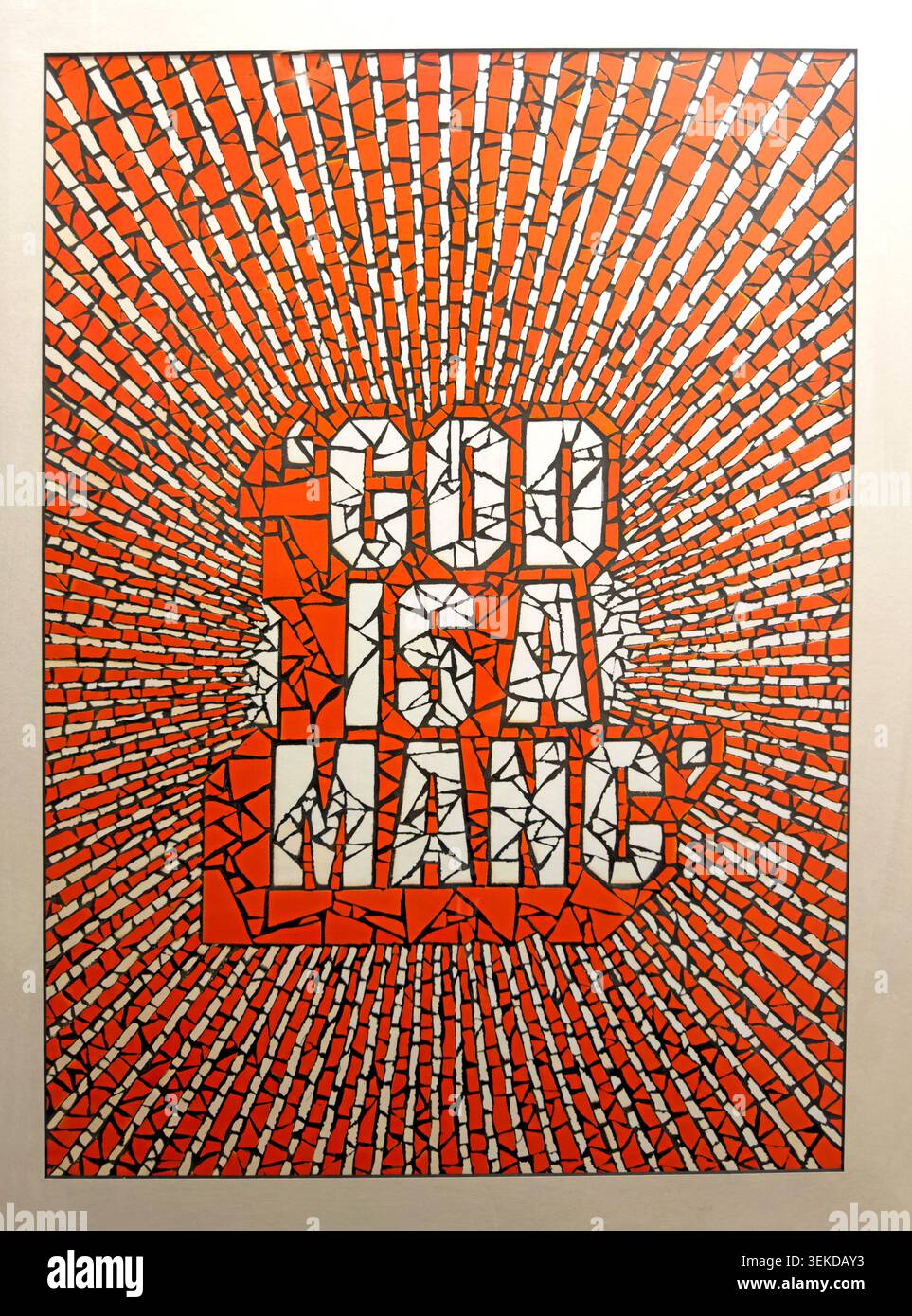Red God Is A Manc poster with mosaic-style lettering celebrating Manchester identity and Mancunian civic pride in music, football, art & culture Stock Photo