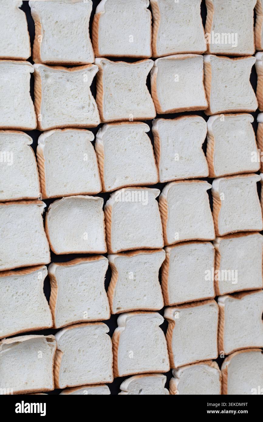 uncooked slices of bread in a row creating a checkered pattern Stock Photo