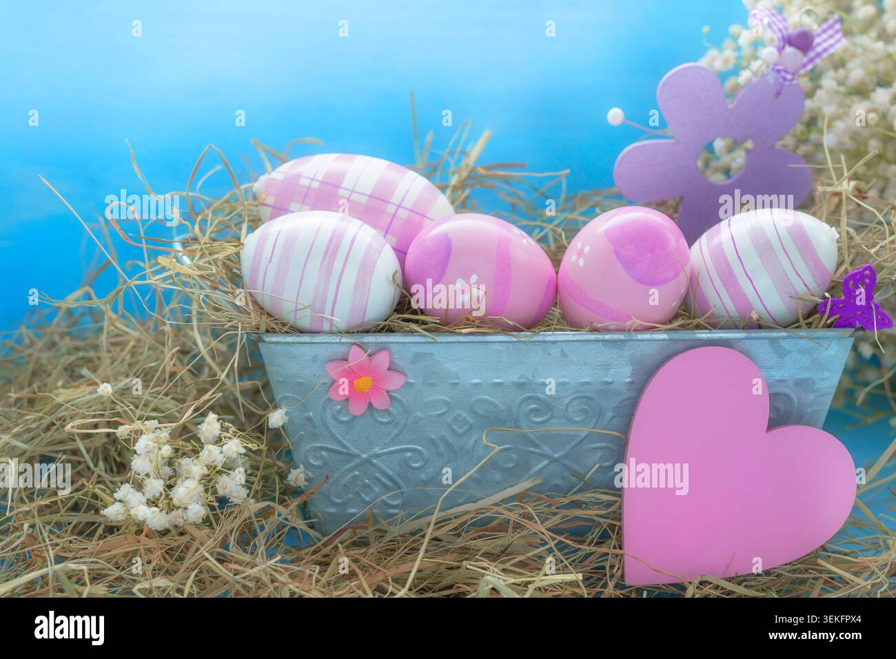 Easter decorations, pink Easter eggs in a flower box with Easterchick, blossoms and heart Stock Photo