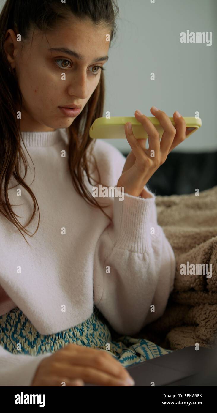 Person in cozy sweater reviews lemon using smartphone camera Stock Photo