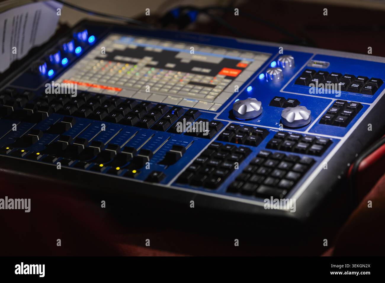 Professional stage lighting console and mixing board control panel featuring faders, knobs and touchscreen interface used in live production, theater Stock Photo