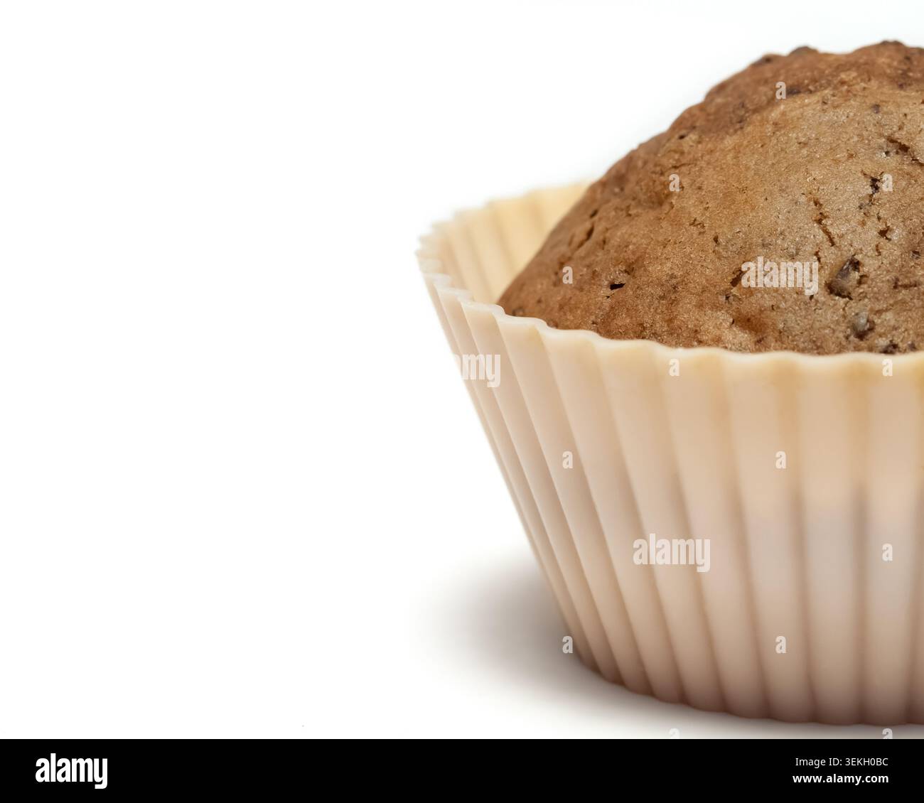 Half of a chocolate muffin in a beige silicone baking cup isolated on a white background with copy paste Stock Photo