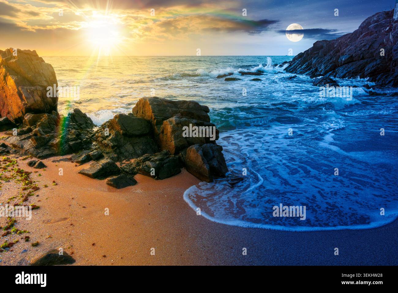 huge stones on the sandy beach. day meet night. wonderful holiday season background at the sea at twilight. sun and moon over clouds on the epic sky a Stock Photo