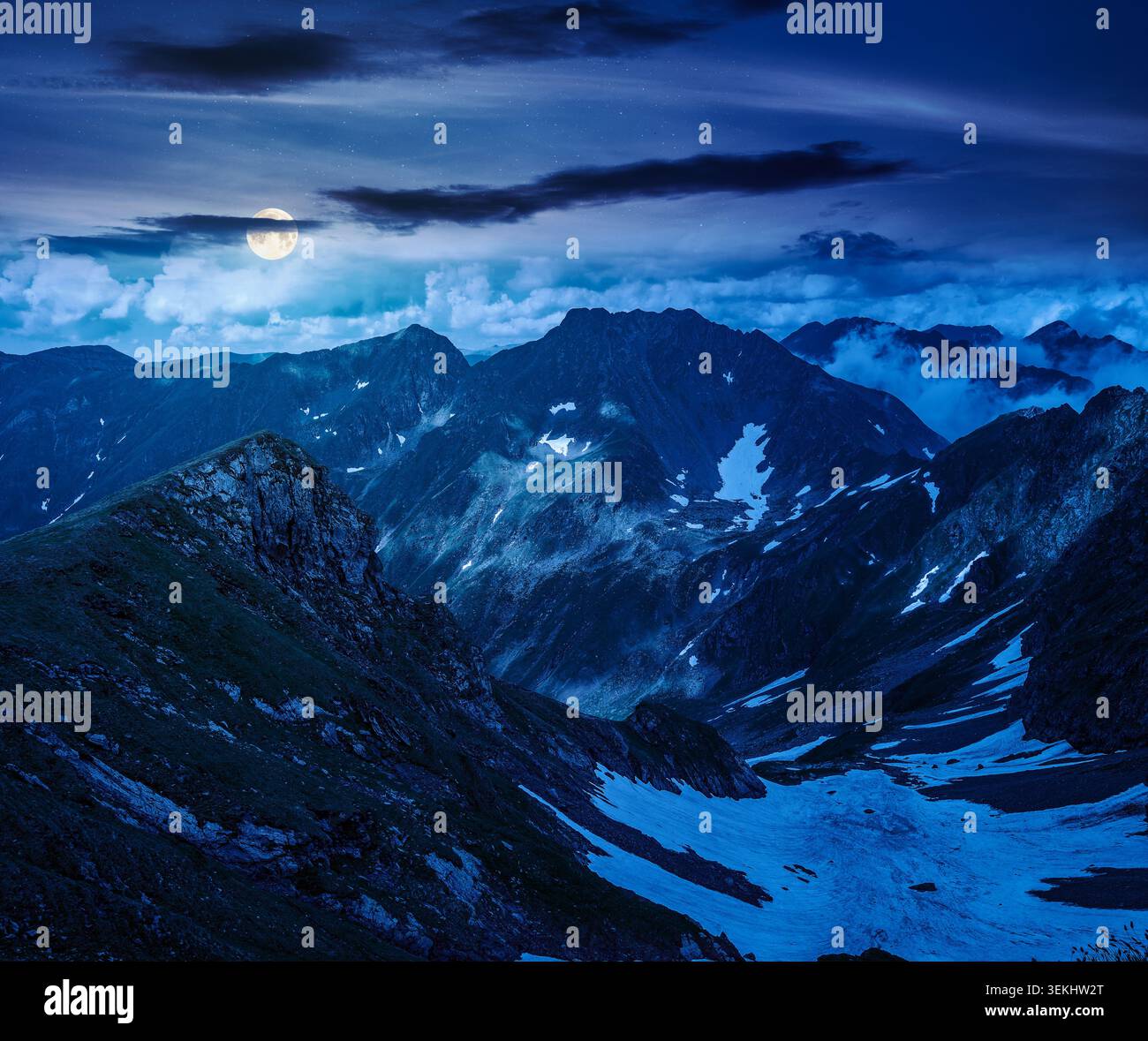 romania mountain landscape in summer at night. full moon over travel background of alpine scenery in fagaras mountain ridge. european summer outdoor a Stock Photo
