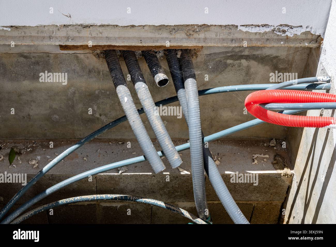 Multiple corrugated plastic conduits and flexible tubes are visible ...