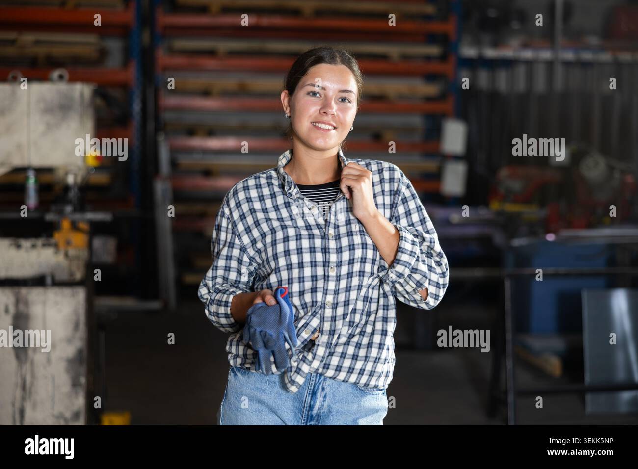 Portrait of positive female worker in workshop of metallurgical plant Stock Photo