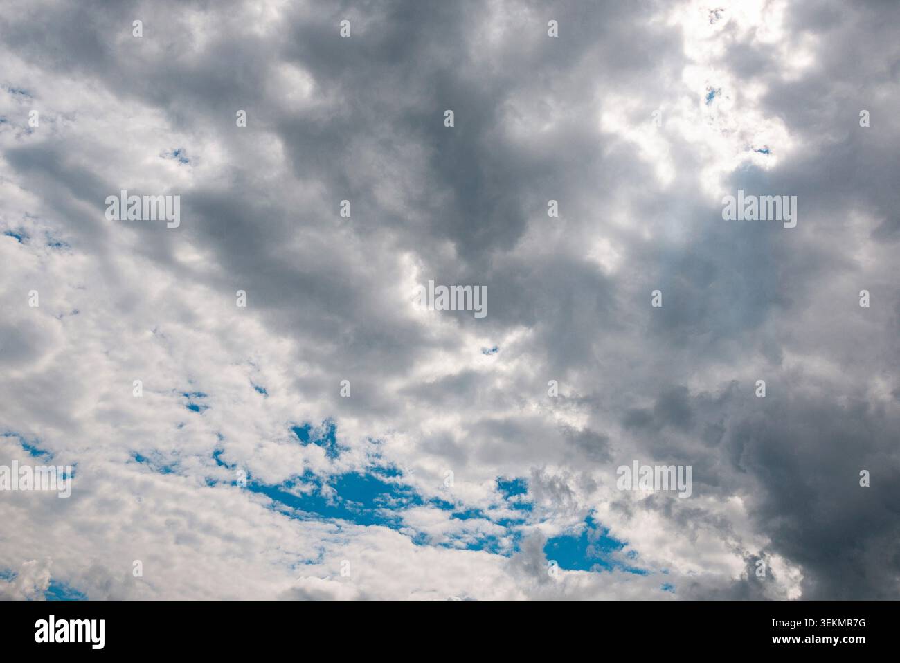 Dark storm clouds with sunlight breaking through dramatic sky background. Stock Photo