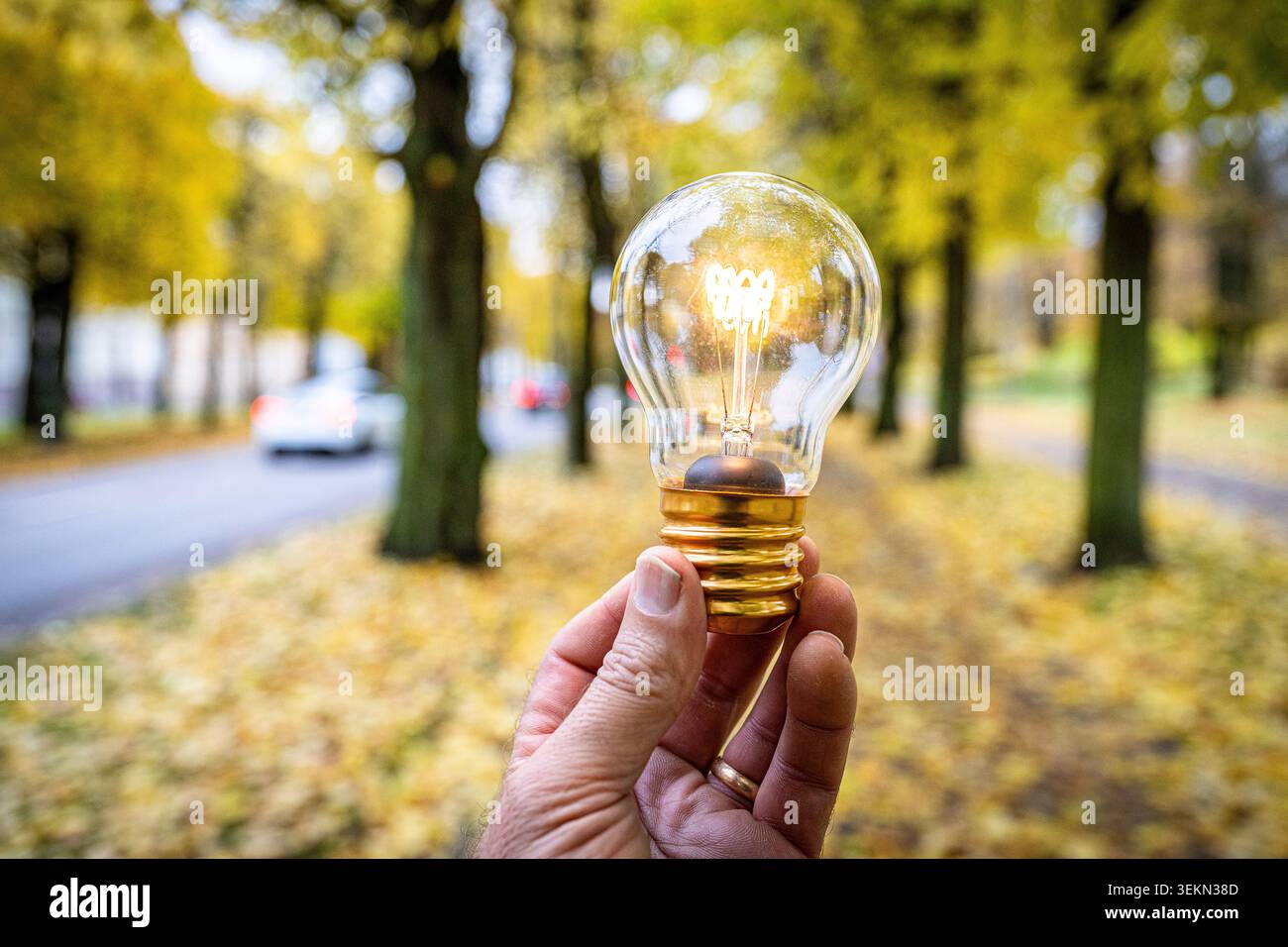 Hand of man holding illuminated light bulb at street Stock Photo