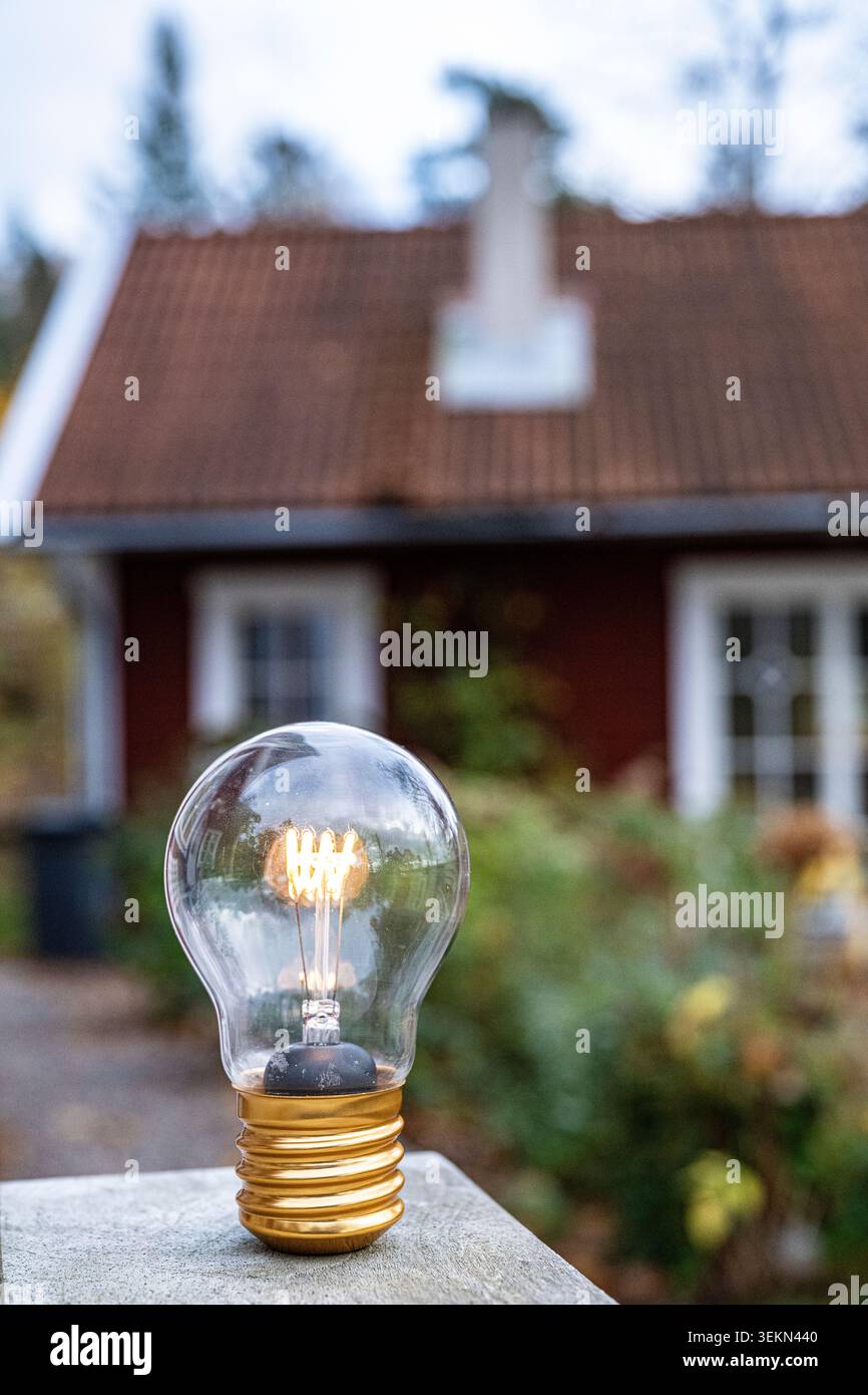 Glowing light bulb kept on outdoor table Stock Photo