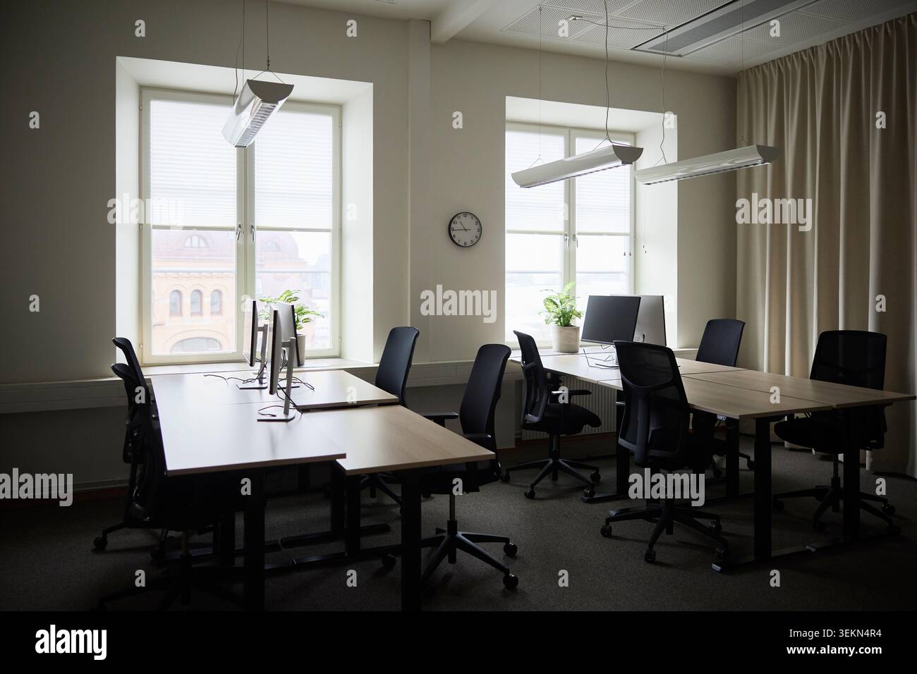Empty desks with computers and chairs in tech office Stock Photo