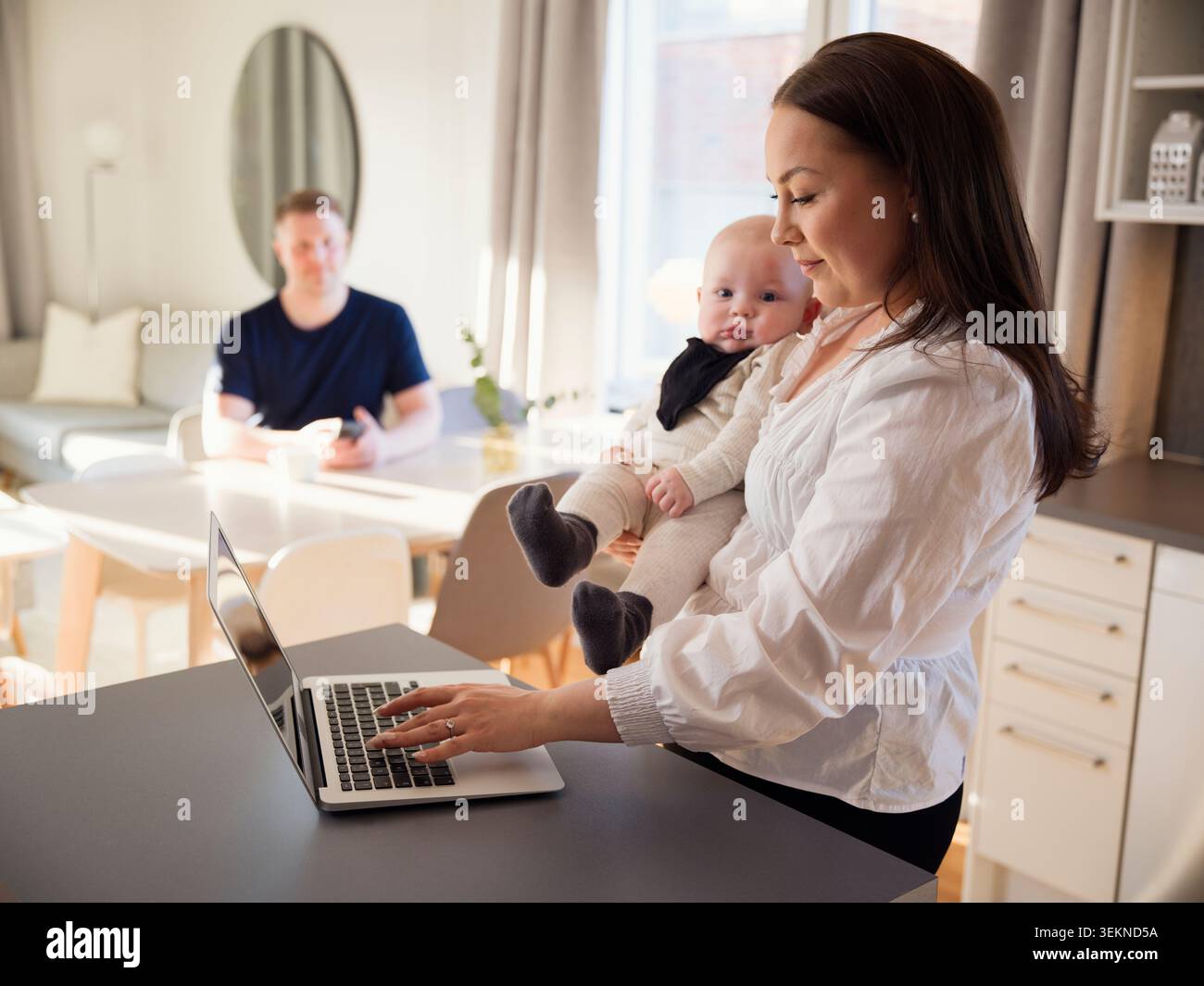 Female freelancer multi-tasking at home Stock Photo