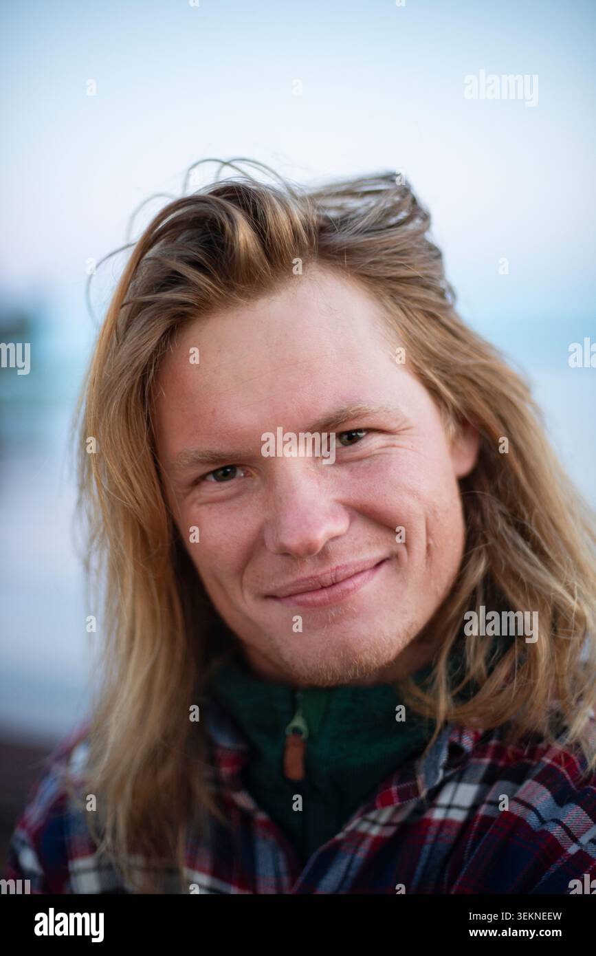 Smiling man with long blond hair Stock Photo