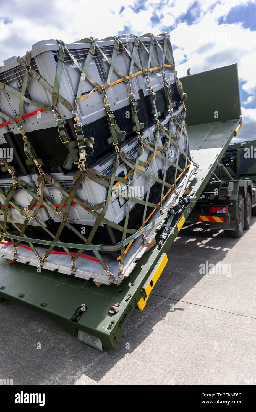 Military hook-lift truck unloads cargo pallet secured netting loading ...