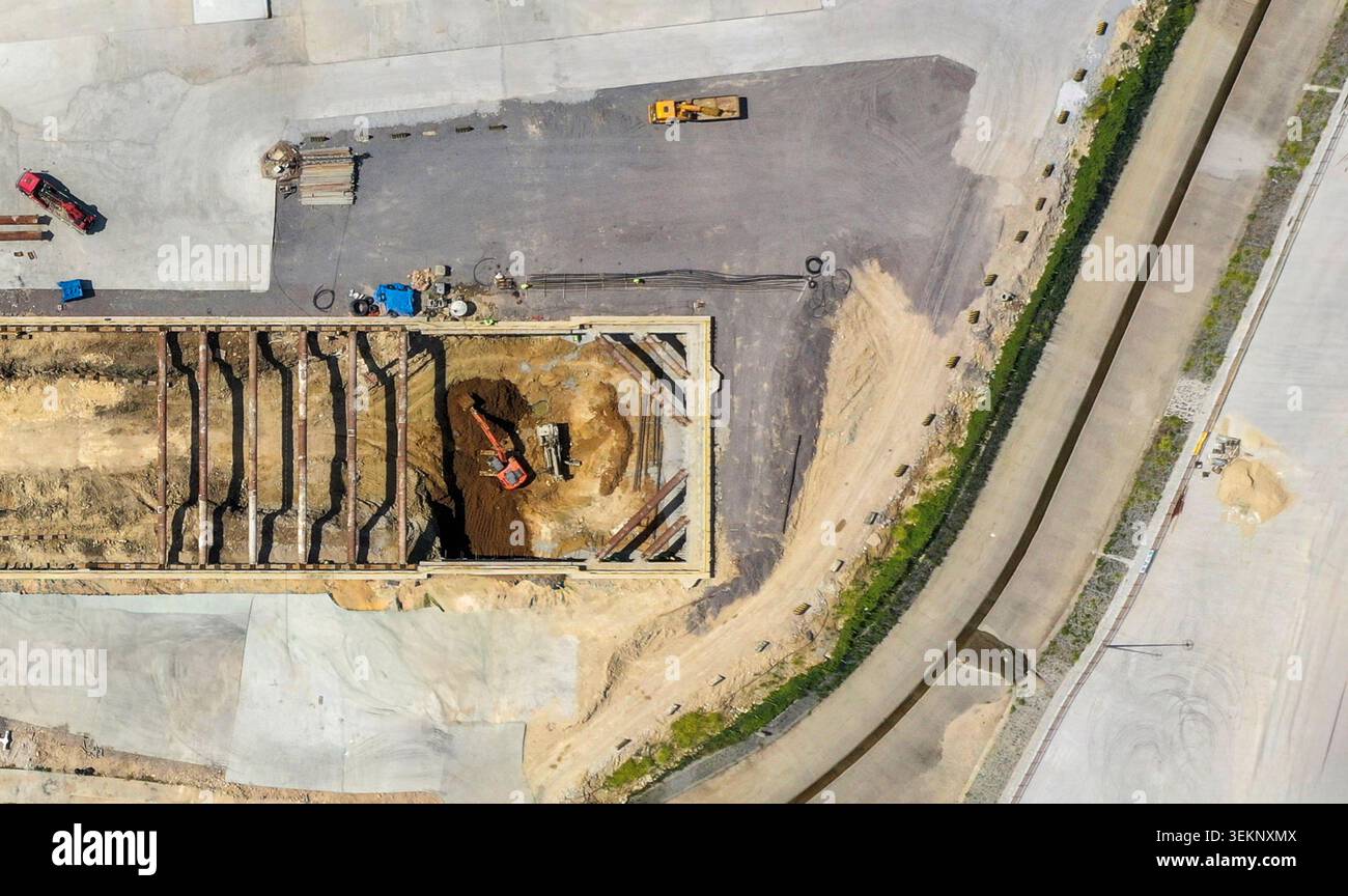 Aerial view of an active construction site with an excavator digging in ...
