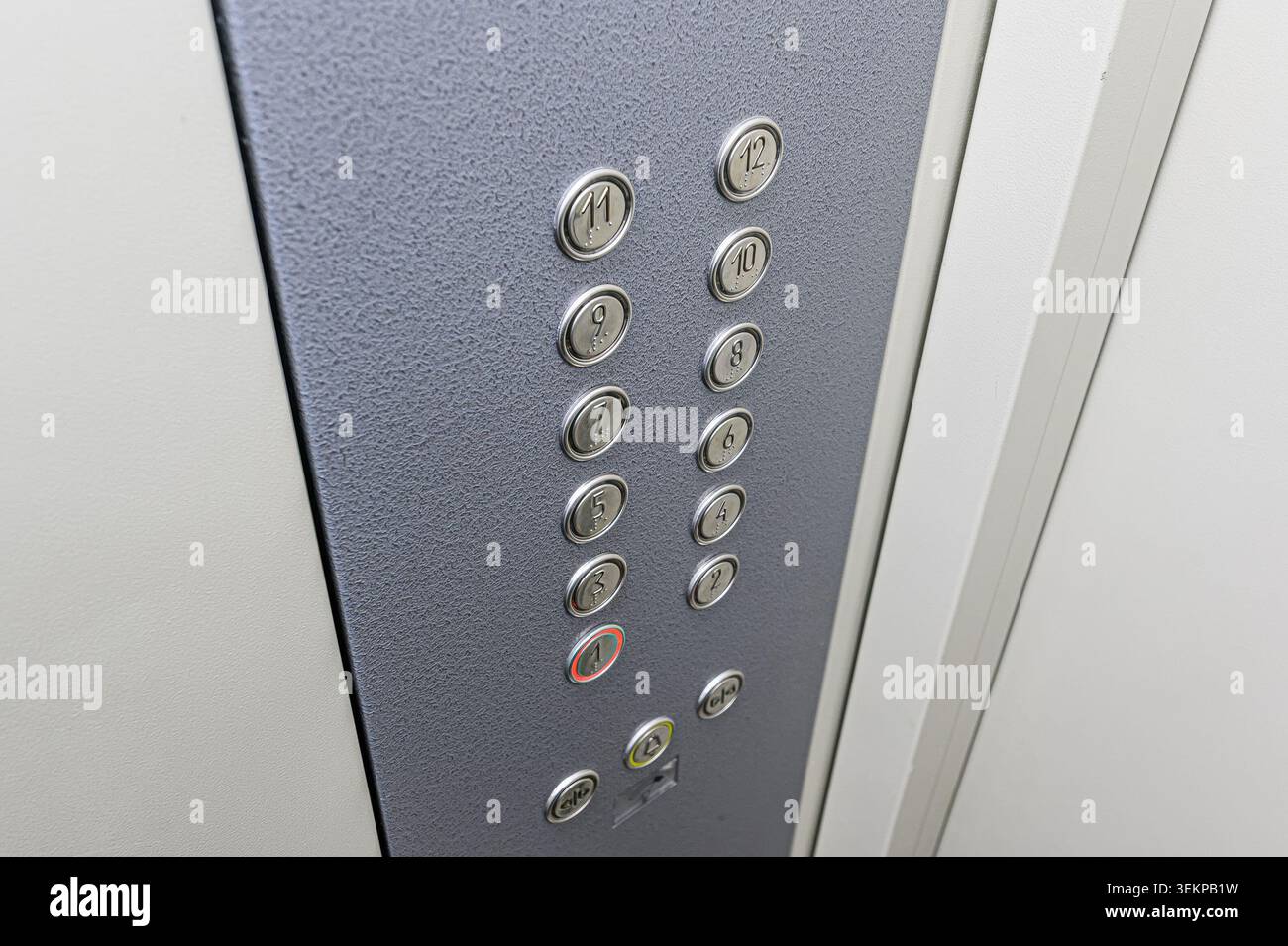 Close-up of an elevator control panel with floor buttons numbered 1-12. Stock Photo