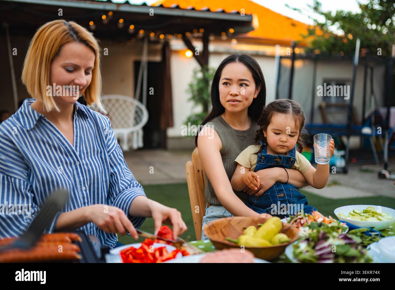 Multi ethnic family enjoying backyard barbecue picnic together Stock Photo