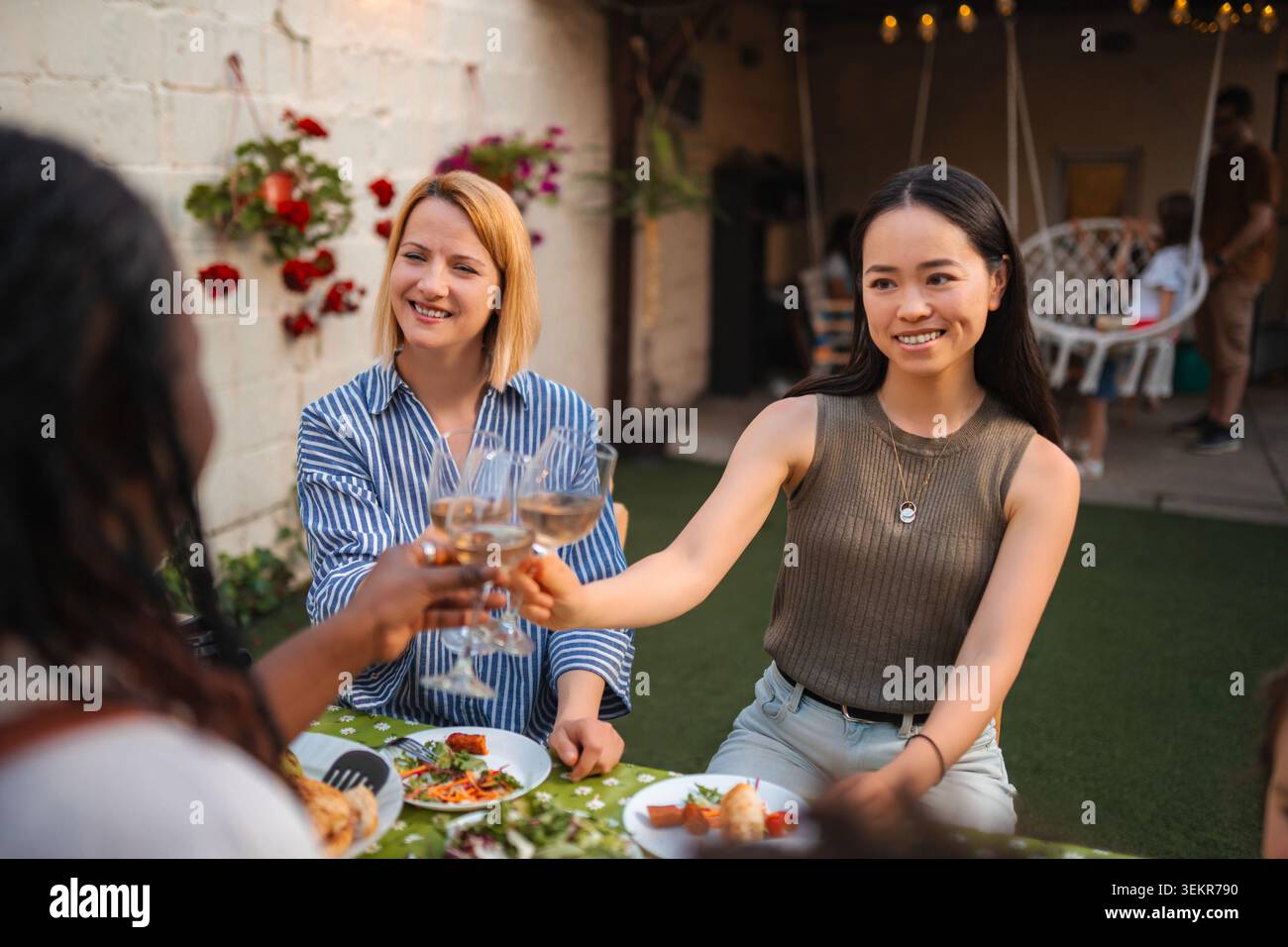 Multi ethnic women friends toasting with wine outdoor Stock Photo