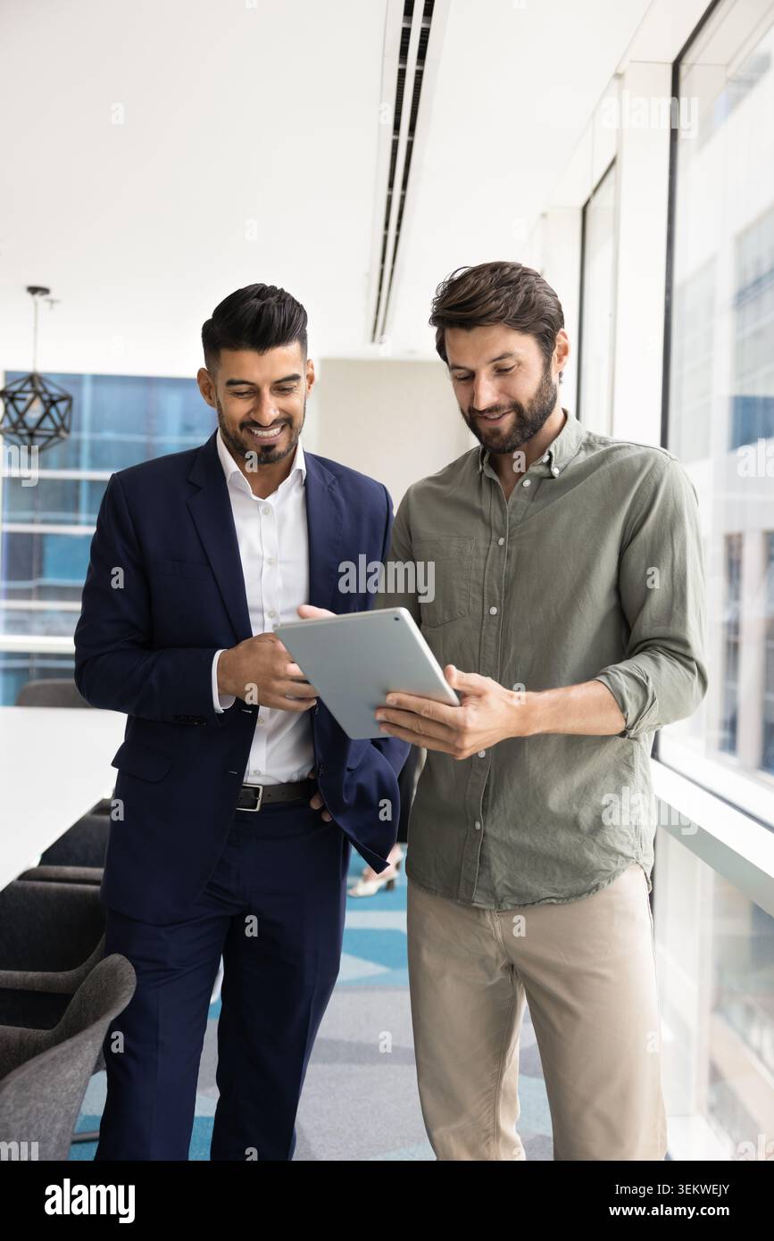 Two multiethnic businessmen collaborating, working together using digital tablet Stock Photo