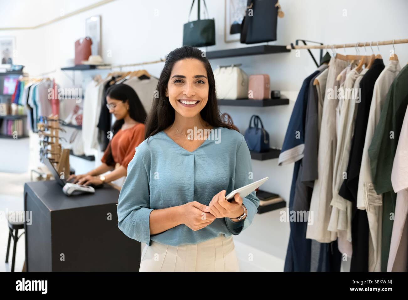 Retail manager with tablet posing in clothing store Stock Photo