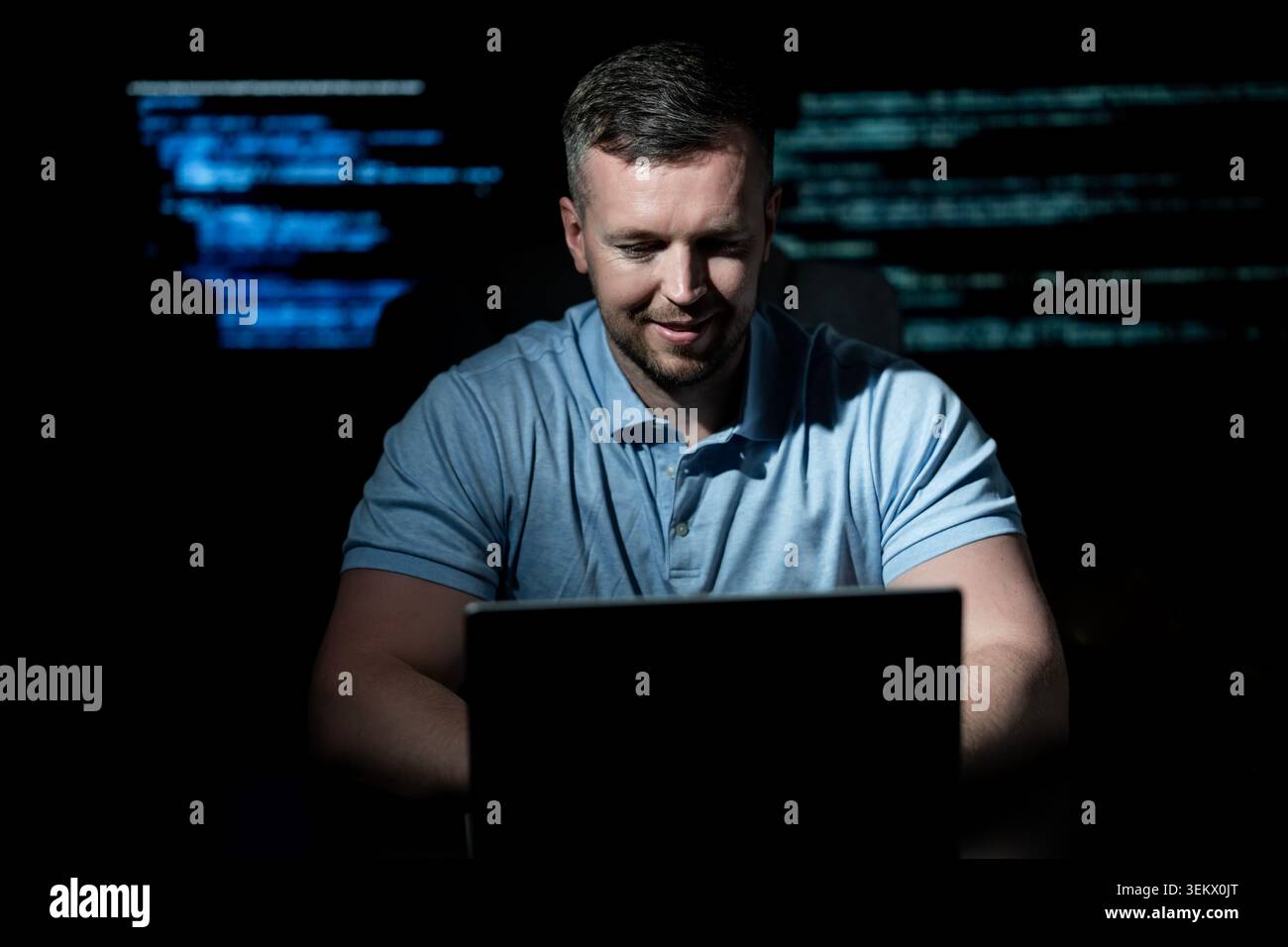 Programmer develops secure software system. Programmer writes programming on computer screen. Programmer monitors network and server logs. Programmer Stock Photo