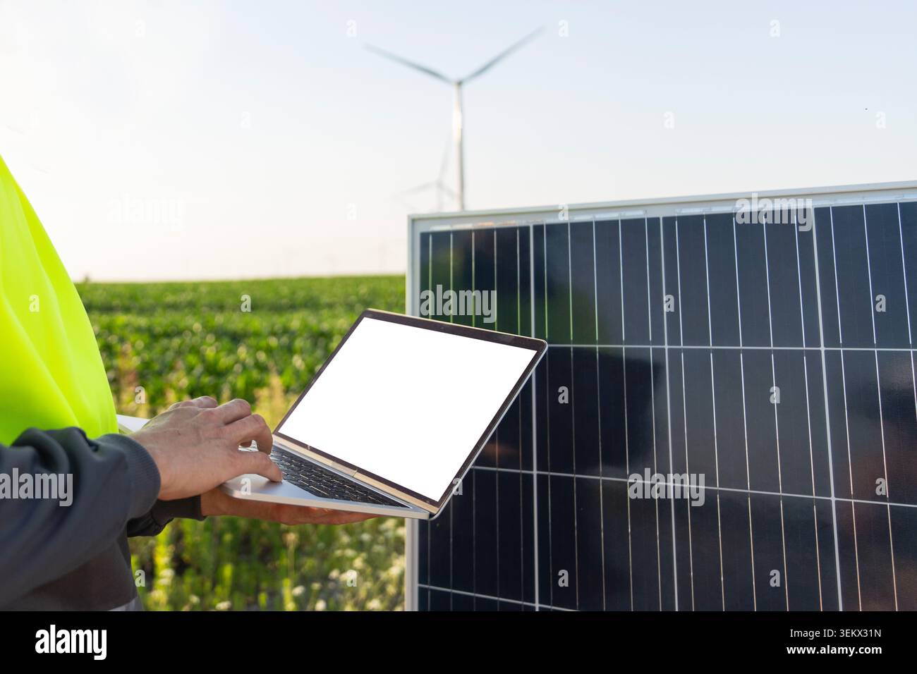 Engineer with laptop next to solar panel Stock Photo