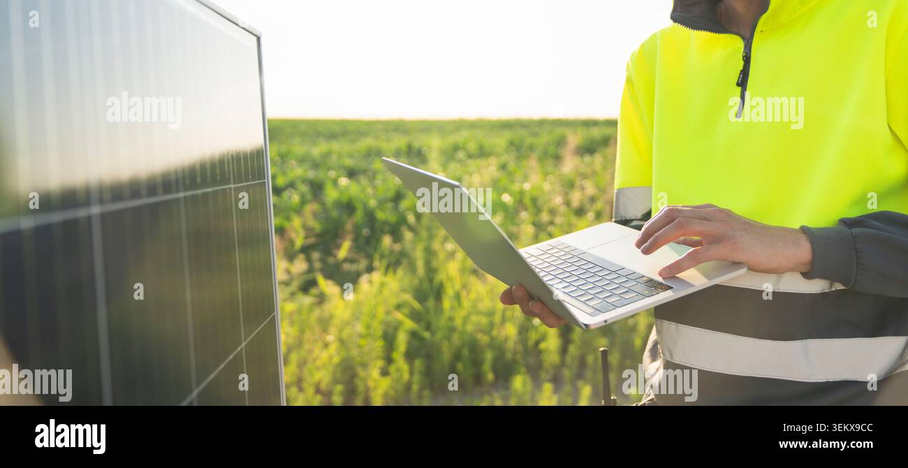 Engineer with laptop next to solar panel Stock Photo