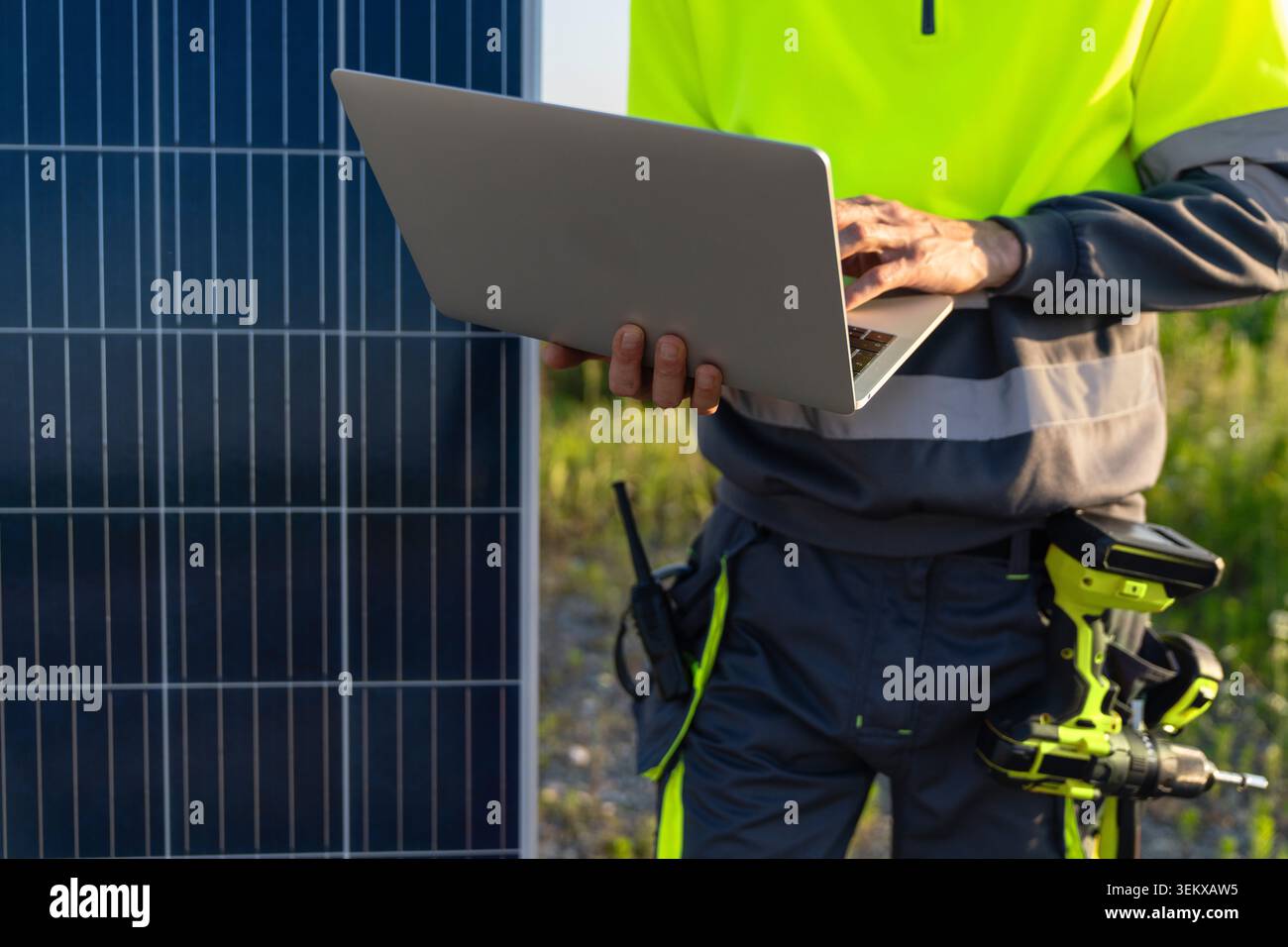 Engineer with laptop next to solar panel Stock Photo
