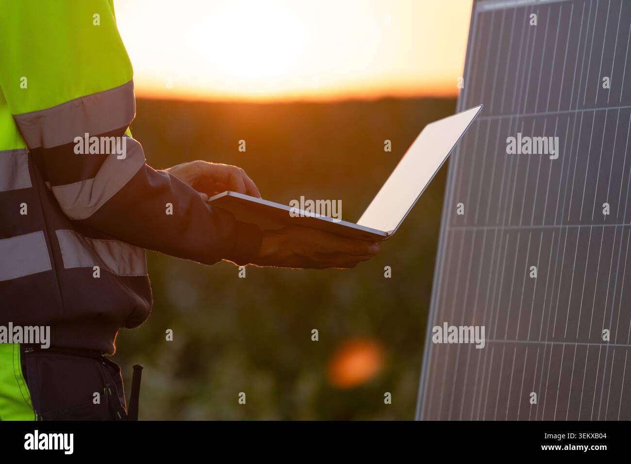 Engineer with laptop next to solar panel Stock Photo