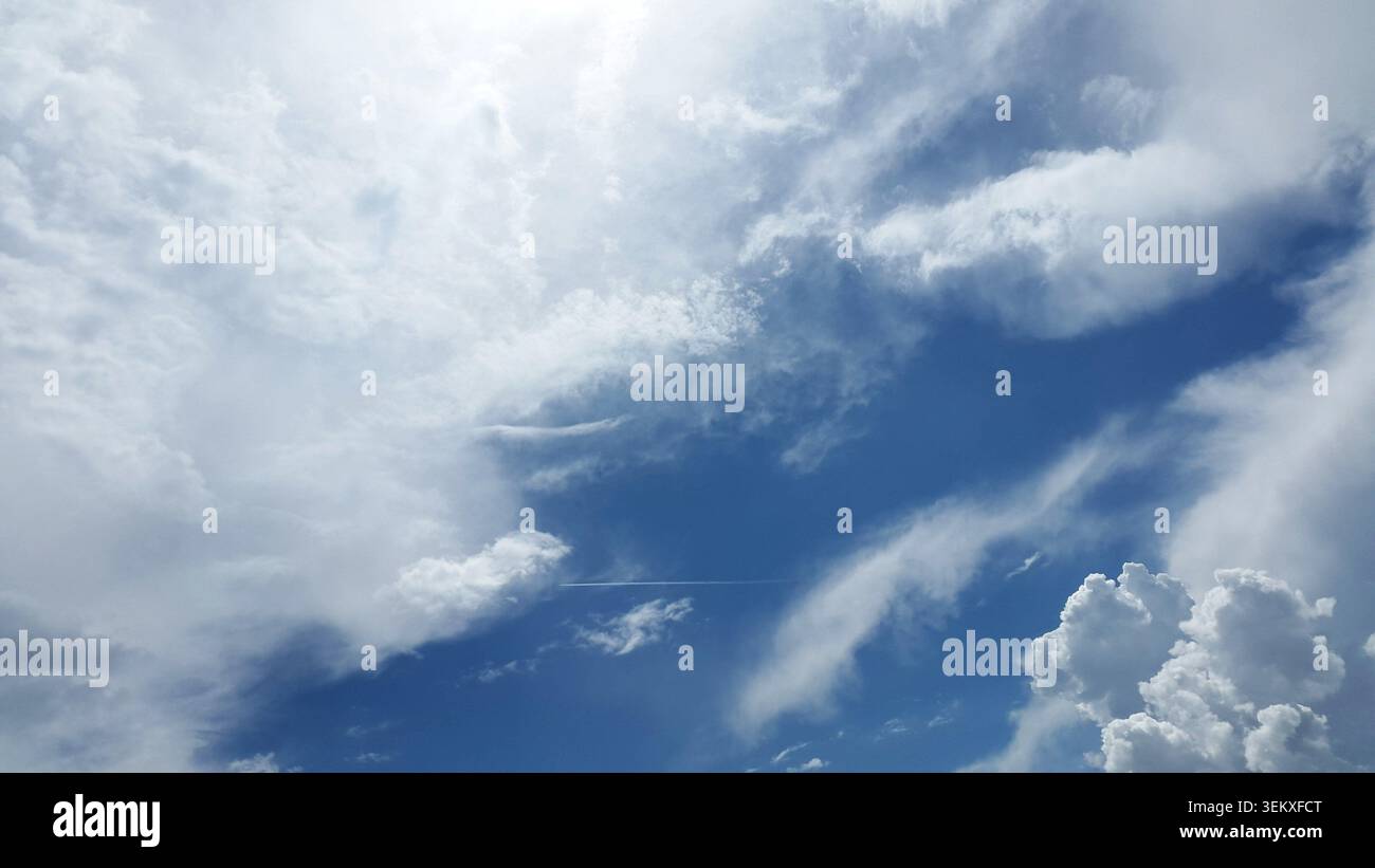 Dramatic Cloud Formation in Bright Blue Sky with Sunlight Breaking Through Stock Photo