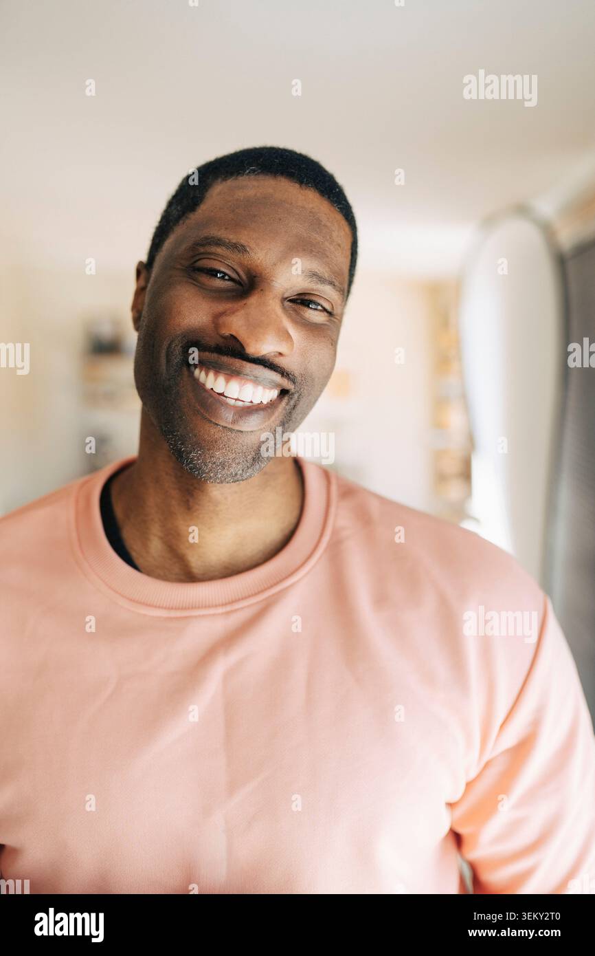 Portrait of happy mature man smiling at home Stock Photo