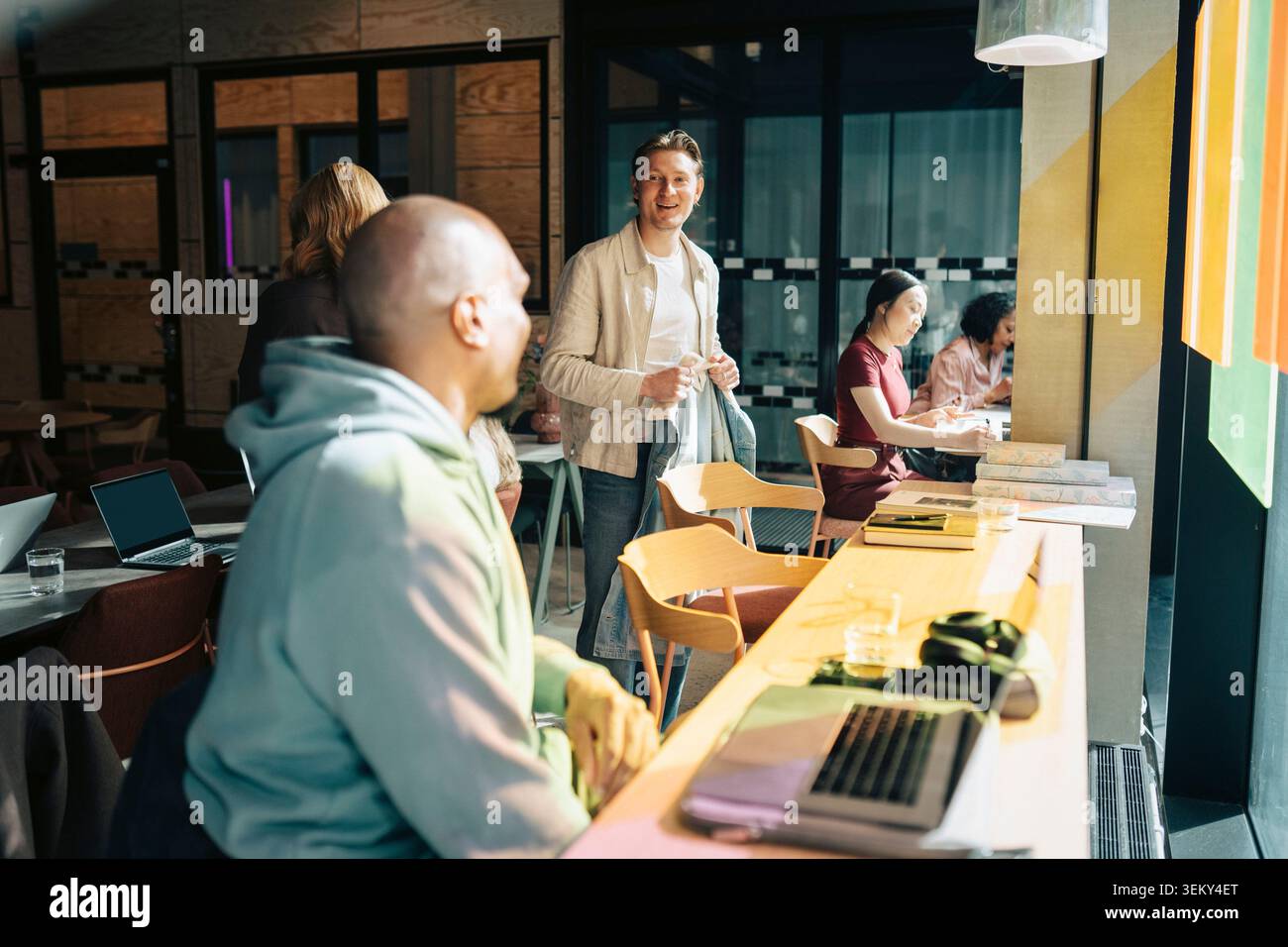 Diverse colleagues interacting and working in modern coworking hub Stock Photo