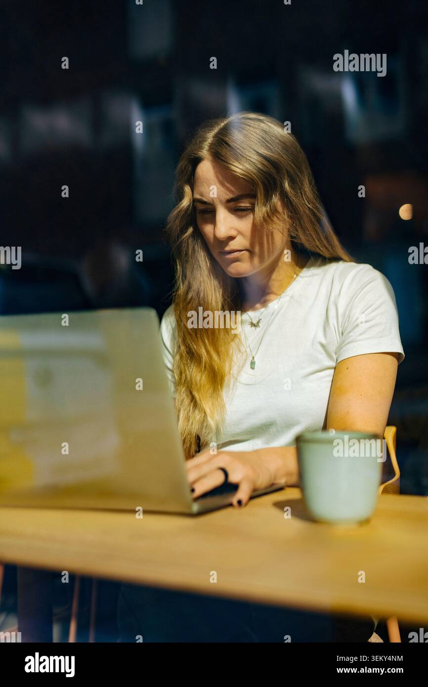 Businesswoman using laptop while working on project inside coworking space Stock Photo