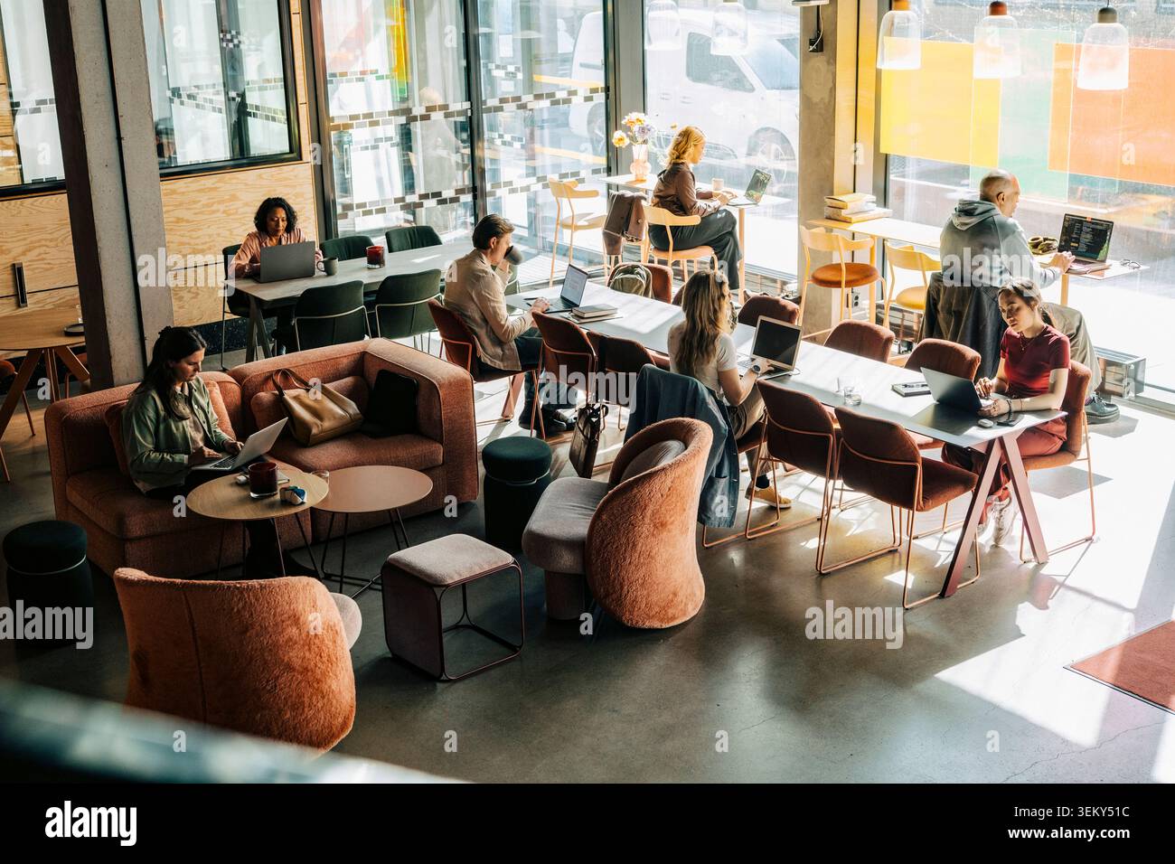 High angle view of diverse professionals working on laptops in modern coworking space Stock Photo