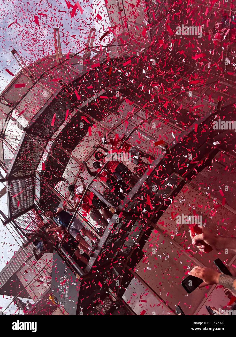 Red and white confetti fills the air as Arsenal supporters celebrate during title festivities in North London, England - Smartphone Captured Stock Image