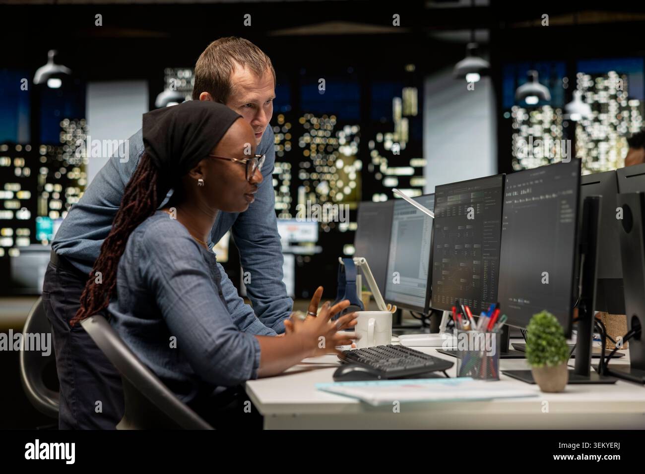 Manager assisting tech startup intern coding advanced artificial intelligence algorithms. Team leader helping worker in office using machine learning models to do automation Stock Photo